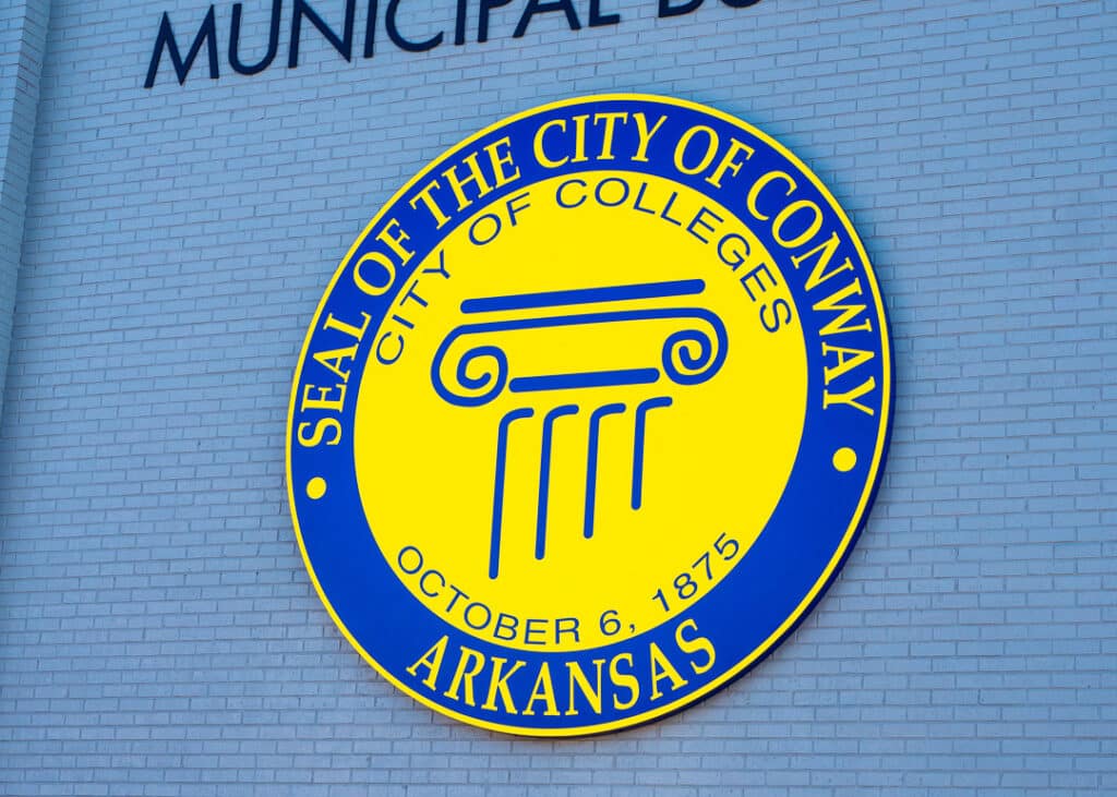 The seal of Conway on the side of the Municipal Building. The seal says. "Seal of City of Conway, Arkansas. City of Colleges. October 6, 1875."